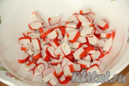 Крабовые палочки нарезать на кусочки толщиной 0,5 см.