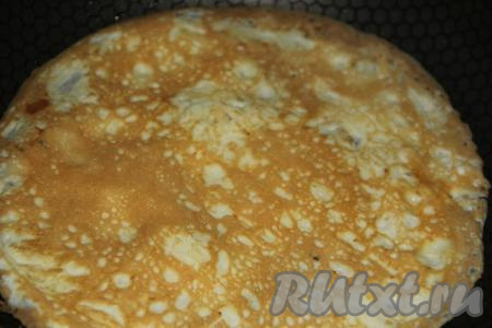 Затем перевернуть, обжарить с другой стороны до золотистого цвета и выложить готовый блинчик на тарелку. Аналогично пожарить второй яичный блинчик. Остудить блинчики.