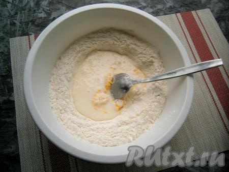 Вливая в мучную смесь частями смесь кефира и соды, замешивать тесто вначале ложкой.