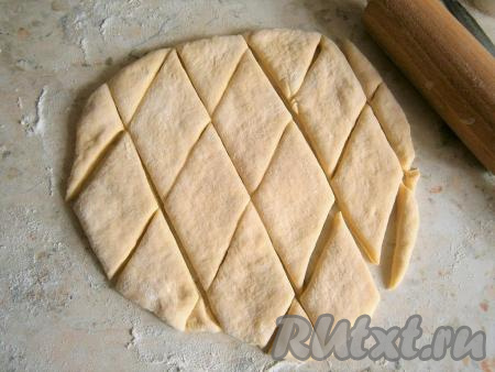 По прошествии времени тесто обмять, разделить на 3-4 части. Каждую часть теста раскатать в пласт (или лепёшку) толщиной около 1 см. Нарезать тесто ромбами.