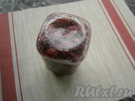 Кастрюлю поместить на огонь, накрыть её крышкой. Довести воду до кипения на среднем огне и далее стерилизовать банки с вишней на небольшом огне около 20 минут. Весь сахар практически должен раствориться, а вишня пустит достаточно много сока, но банки будут не полными. Если до верха банки пустоты не слишком много (это зависит от сочности ягод), просто долейте немного кипятка. Если же вишня осядет и ее будет половина, дополните одну банку вишней и соком из другой банки. Так вышло у меня, поэтому в итоге получилась одна баночка вишни. Банку закрутить и перевернуть. Если на дне вы увидите немного сахара - ничего страшного, при самостерилизации (укутывании) он полностью растворится.