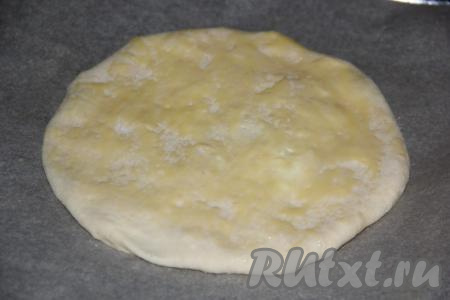 Выложить получившуюся лепёшку на противень, застеленный пергаментом. Смазать верх лепёшки яичным желтком. Таким же образом сформировать вторую лепёшку.