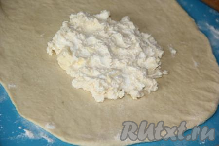 На середину раскатанного теста выложить половину сырной начинки.