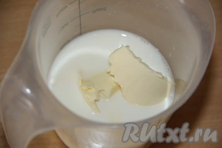 В отдельную ёмкость (я взяла стакан) влить молоко, добавить сливочное масло, нарезанное на кусочки.