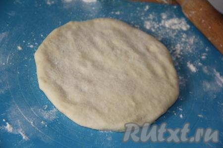 Перевернуть тесто с начинкой защипом вниз и аккуратно раскатать в лепёшку размером, примерно, 20 см.