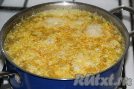 Влить тонкой струйкой яйцо в кипящий суп, интенсивно перемешивая, затем уменьшить огонь и проварить ещё 3-5 минут.