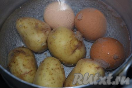 Картофель в мундире и яйца нужно отварить до готовности, для этого вымытые яйца и картошку отправляем в кастрюлю с холодной водой, ставим на огонь, с момента закипания варим на небольшом огне яйца 10 минут, а картофель - до готовности (примерно, 20 минут). Готовность картофеля проверяем, прокалывая клубни ножом (если нож легко прокалывает картофелину - значит готова).