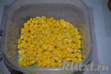 Баночку консервированной кукурузой открываем и сливаем из неё жидкость. Высыпаем кукурузу в миску.