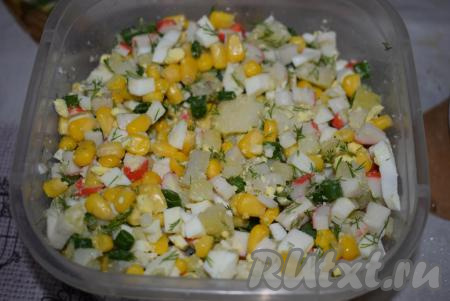 К кукурузе добавляем нарезанные картошку, крабовые палочки, зелёный лук, зелень, яйца и перемешиваем.