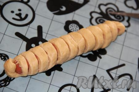 С помощью ножниц сделать разрезы, прорезая сосиску и верх теста  (как на фото), внизу тесто должно остаться целым.