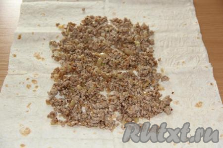 На лист лаваша выложить фарш и разровнять, оставляя края лаваша чистыми.