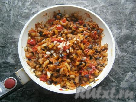 Хорошо перемешать и готовить баклажанную икру на сковороде на небольшом огне около 15 минут, периодически перемешивая. Минут за 5 до готовности добавить измельчённый чеснок.