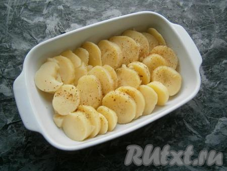 Остывший варёный картофель очистить и нарезать на кружки толщиной около 1 см. Кружочки картошки выложить внахлёст в форму для запекания (у меня форма размером 23х16 см), немного посолить и посыпать специями.