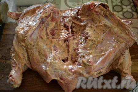 Берём тушку птицы и хорошо её обмазываем со всех сторон маринадом. Маринада не жалеем, именно благодаря ему наша запечённая курочка получится очень сочной и вкусной.