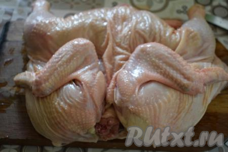 Разрезаем курицу по грудке пополам и распластываем птицу.