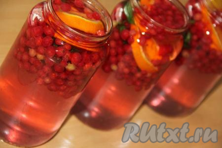 Банки с красной смородиной, апельсином и мятой до самого верха залить горячим сиропом, прикрыть предварительно прокипячёнными крышками.