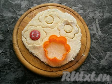 Тесто разделить на несколько частей. Каждую часть теста раскатать в лепёшку толщиной около 1 см. Формочкой (или стаканом) вырезать фигурки (или лепёшки-кружки), пробкой от пластиковой бутылки вырезать кружочек в середине фигурок (или лепёшек).