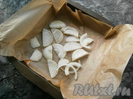 Форму застелить пергаментом, выложить слой нарезанного полукольцами (или кольцами) репчатого лука, полить его растительным маслом.