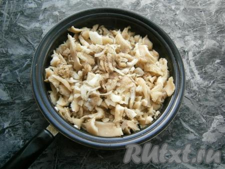 На сковороду к вешенкам добавить очищенный и произвольно нарезанный лук, посолить и поперчить.