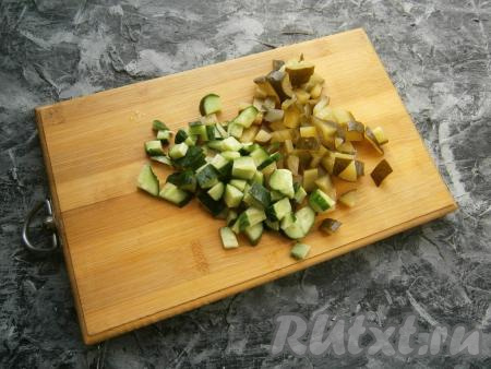 Нарезать кубиками свежий и маринованный огурцы.