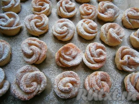 Для того чтобы творожное печенье стало ещё более красивым и похожим на розы, его нужно смазать любым сиропом или протёртым джемом из красных ягод, дать ему немного остыть, а затем посыпать сахарной пудрой.