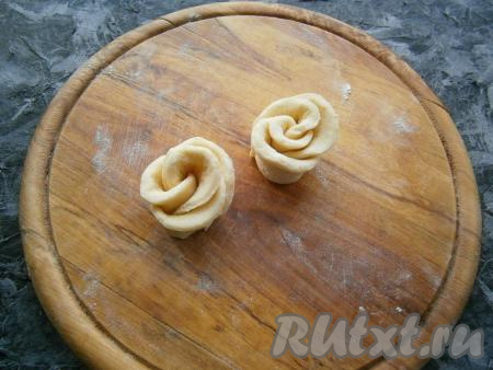 Срезанной стороной поставить тесто вниз, а "лепесточки" расправить, сформировав заготовку розочки. Если концы теста будут выступать снизу, защипнуть их.