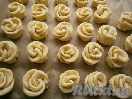 Таким образом сформировать всё печенье в виде розочек, выложить его на противень, застеленный бумагой для выпечки, и отправить в разогретую духовку.