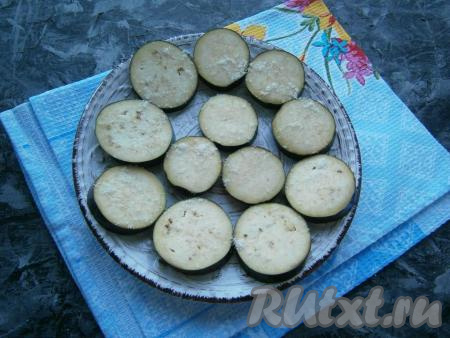 Баклажан нарезать кружочками толщиной около 0,7-1 см, разложить в один слой на подходящей для микроволновой печи тарелке, посолить и оставить на 20 минут.