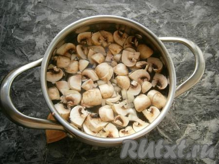 Шампиньоны вымыть, обсушить и нарезать на средние кусочки. Налить в кастрюлю воду, довести её до кипения, посолить. Выложить в закипевшую воду половину нарезанных шампиньонов, добавить картофель, довести до кипения, а затем варить на небольшом огне до готовности картошки (примерно, 20-25 минут).