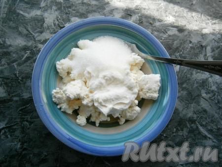 Для приготовления прослойки к мягкому творогу добавить сметану, всыпать сахар и ванильный сахар.