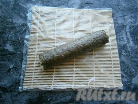 Помогая циновкой, свернуть всё в плотный ролл.