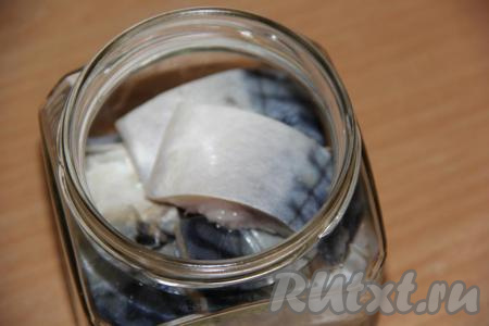 На дно банки выложить перец горошком и лавровый лист. Затем сложить кусочки скумбрии&nbsp;в банку мякотью вниз. У&nbsp;меня ёмкость банки 480 мл.