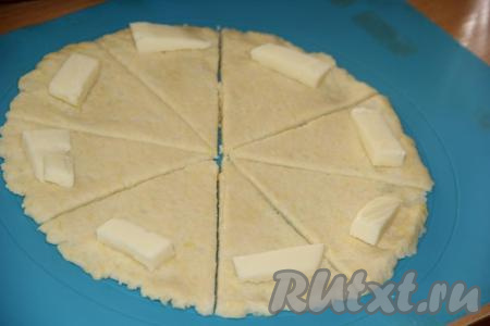 На широкий край каждого сектора положить по кусочку сыра. Начиная заворачивать тесто с широкого края сектора, сформировать рогалики.