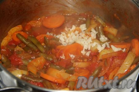 С момента закипания варить лечо со стручковой фасолью 25 минут на медленном огне, периодически помешивая. В конце приготовления добавить мелко нарезанный чеснок.