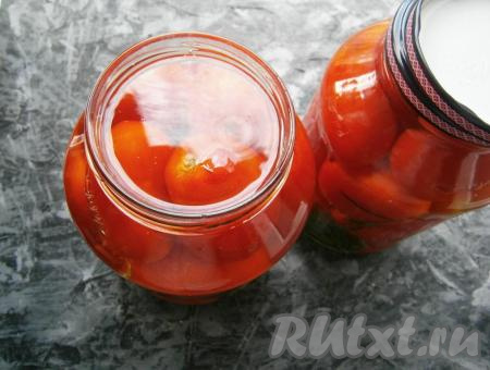 Банки с помидорами до самого верха залить крутым кипятком и, накрыв прокипячёнными крышками, оставить на 10 минут.