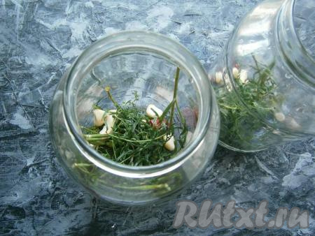 Выложить на дно тщательно вымытых банок по 2 зубчика чеснока, по 1-2 веточки укропа, по кусочку хрена, по половинке перца чили и&nbsp;по веточке тархуна.