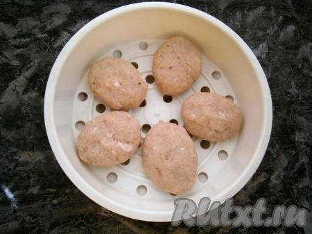 В большую чашу мультиварки налить воду на 1/3 объёма, сверху разместить чашу для варки на пару. В чашу для варки на пару выложить сформированные небольшие  свиные котлеты.