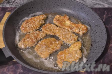 Жарить куриные наггетсы на среднем огне до румяной корочки с двух сторон (по 3-4 минуты с каждой стороны).