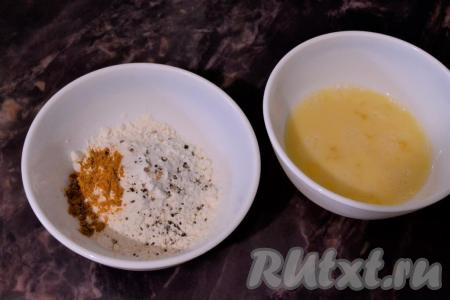 В одну пиалу (или тарелку) насыпать муку, добавить порошок карри, щепотку соли и щепотку чёрного молотого перца, перемешать. В другую пиалу разбить яйцо, хорошо его взбить вилкой.