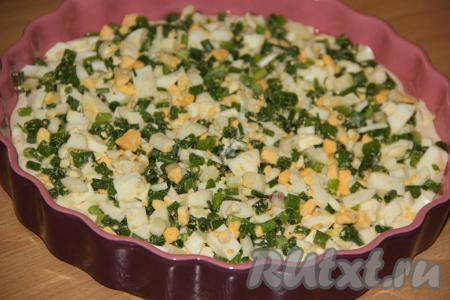 Затем выложить зелёный лук, смешанный с варёными яйцами,&nbsp;разровнять.