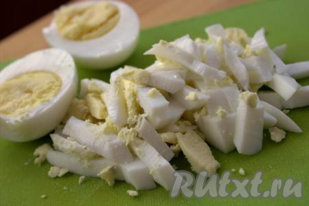 Яйца отварить вкрутую (в течение минут 10 с момента закипания воды), затем охладить, очистить, нарезать длинными кусочками (можно натереть на крупной тёрке).