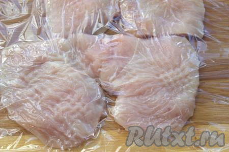 Вымыть куриное филе, обсушить с помощью бумажных полотенец, а затем обрезать с мяса плёнку и лишний жир. Выложить куриное мясо на разделочную доску, нарезать на плоские порционные кусочки и,&nbsp;накрыв пищевой плёнкой, отбить филе кухонным молоточком.