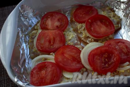 Жаропрочную форму застелить фольгой, выложить в один слой заготовки&nbsp;куриного&nbsp;филе. Поверх мяса разложить помидоры, нарезанные на кружочки.