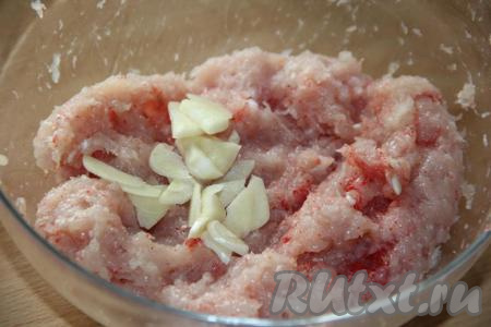 Перемешать фарш со специями. Чеснок очистить, нарезать на тонкие пластинки, добавить в фарш.