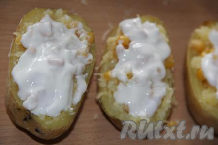 Смазать начинку картофельных лодочек сметаной и слегка перемешать.