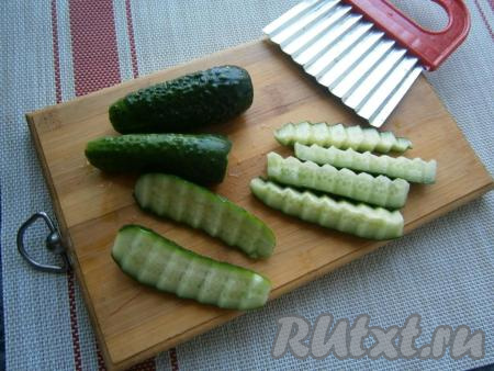 Обрезать края огурчиков. Нарезать огурцы длинными кусочками с помощью фигурного ножа (как на фото). Если нет такого ножа, нарежьте огурчики брусочками.