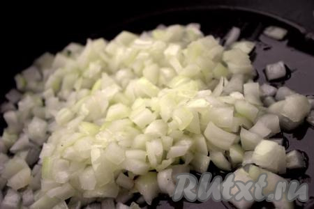 Лук и морковь очистить. Нарезать лук небольшими кубиками, выложить в сковороду с растительным маслом и обжарить на среднем огне до мягкости (в течение 3-5 минут), помешивая.