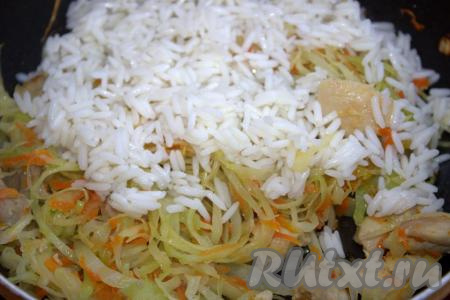 Когда капуста, тушёная с курицей и овощами, будет готова, добавить рис, хорошо перемешать.