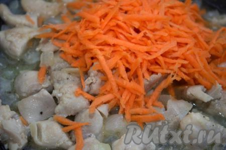 Затем к луку и кусочкам куриного мяса добавить натёртую на крупной тёрке морковь и обжаривать минут 5, иногда помешивая.