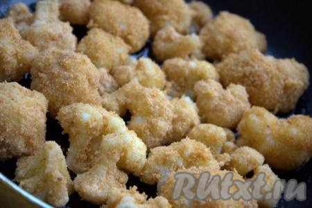 В сковороду влить растительное масло и выложить в один слой кусочки цветной капусты в панировочных сухарях.